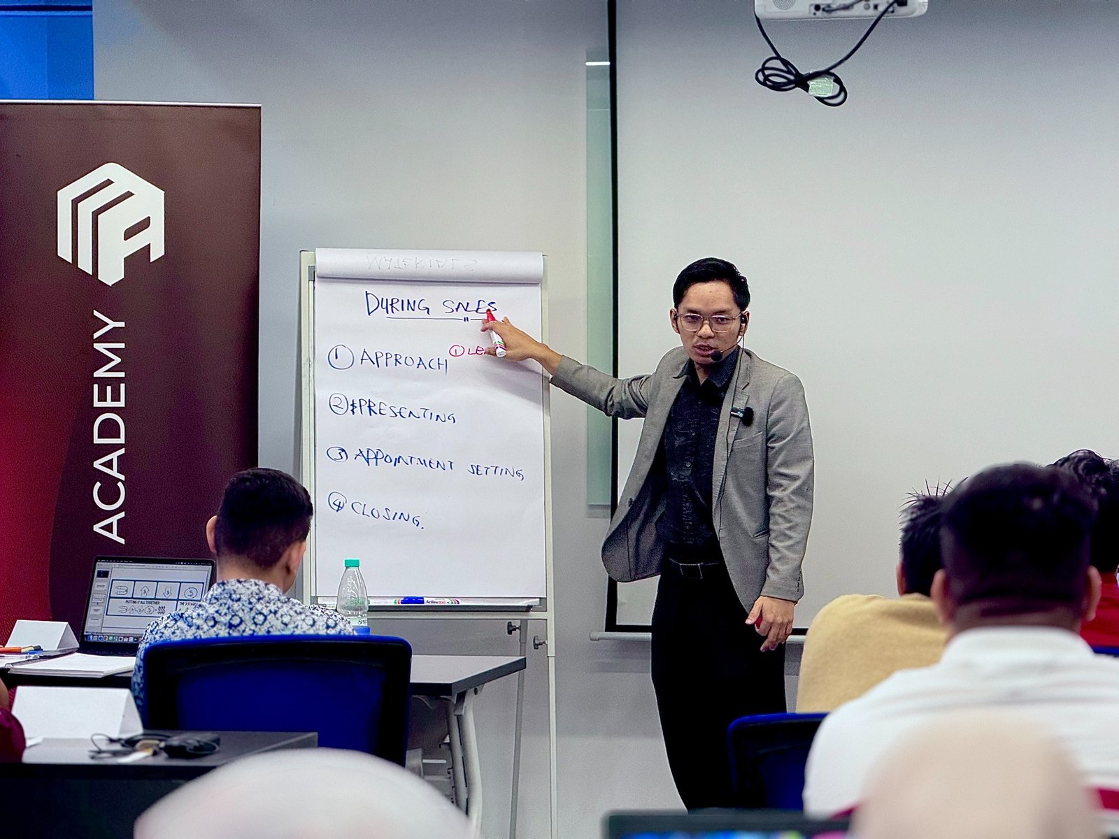 Trainer explaining the sales process using a flip chart
